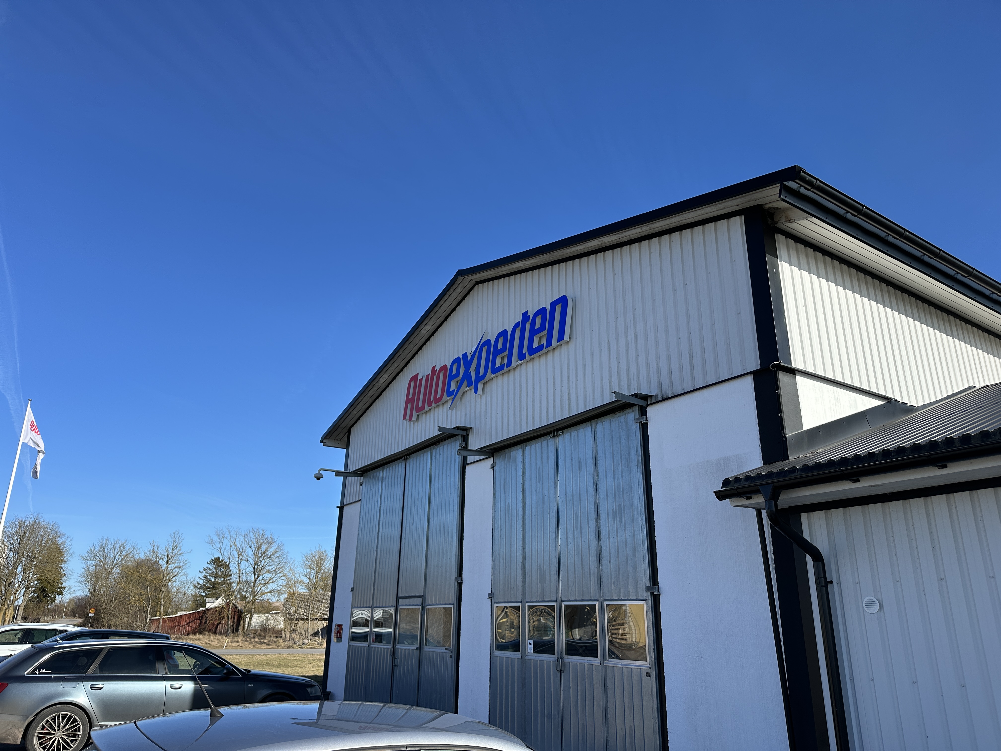 Autoexperten-skylt på verkstadsfasad i skandinavisk stil