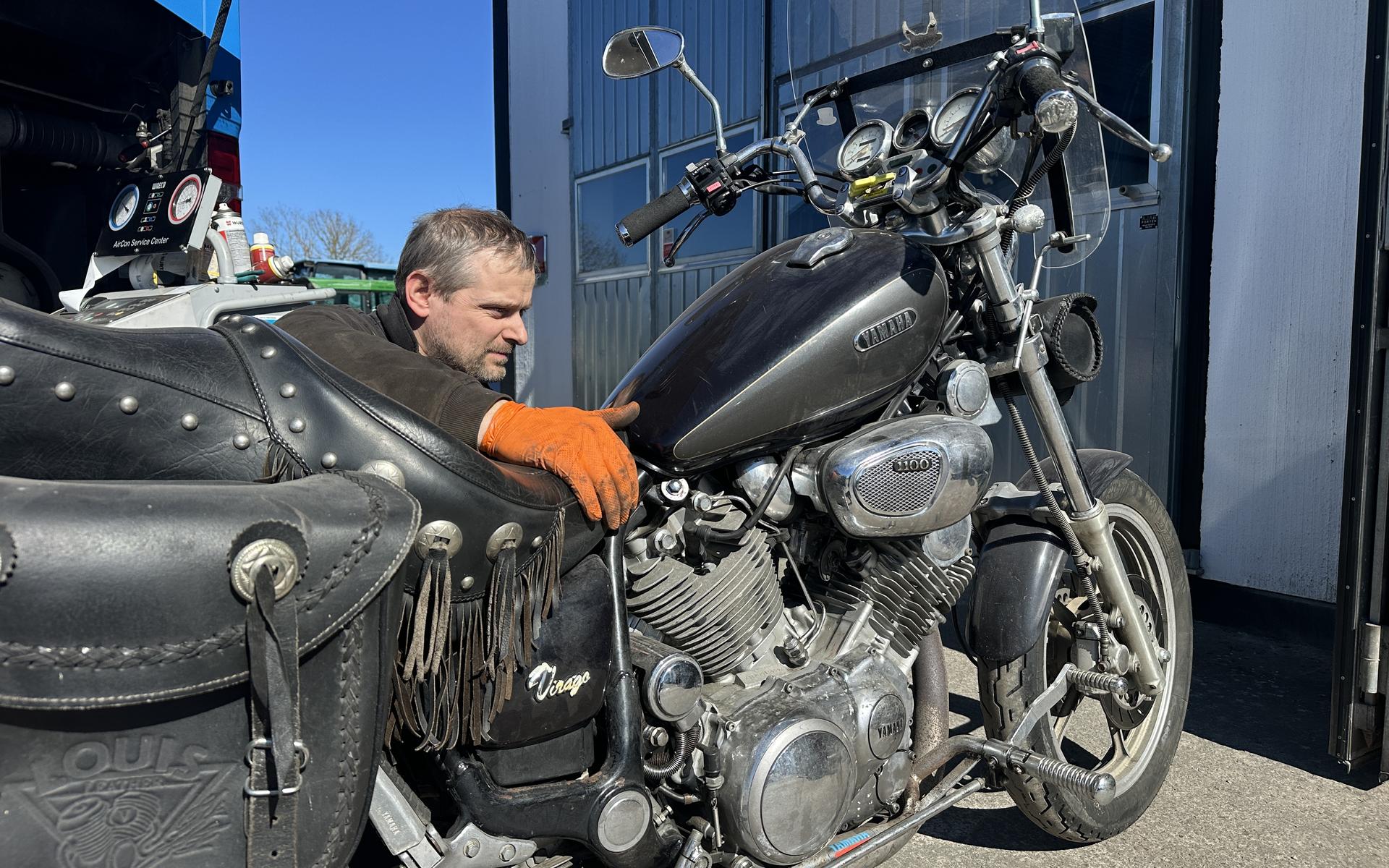 Motorcyklist i skinnställ pratar med Björn utanför verkstaden.